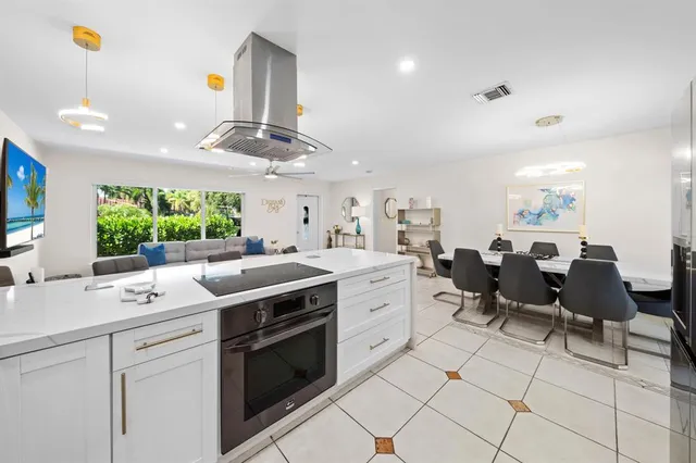 a kitchen with a stove a sink a dining table and chairs