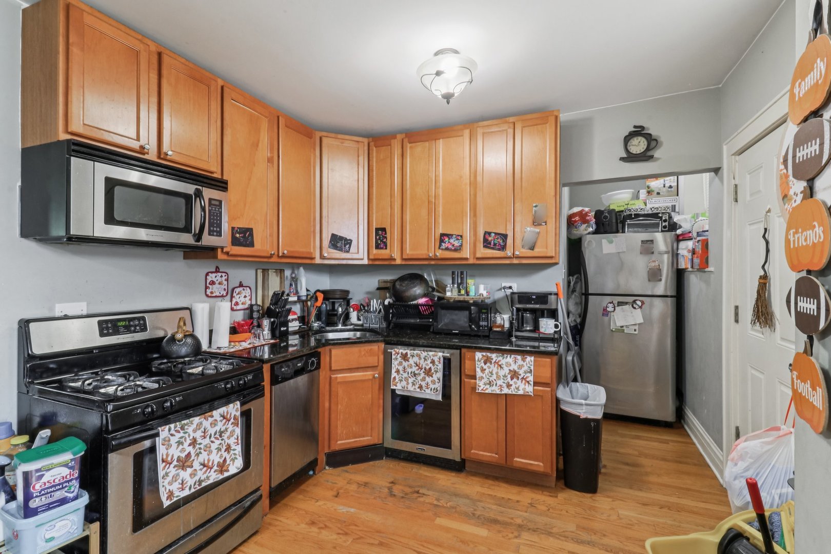 5621 North Spaulding Avenue, Unit 3S Chicago, IL 60659 - Photo 11 of 28 a kitchen with stainless steel appliances granite countertop a stove top oven a sink dishwasher and a refrigerator with wooden cabinets