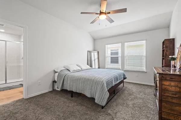 a bedroom with a bed a dresser and a window