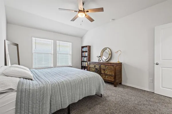 a bedroom with a bed a chandelier and a window