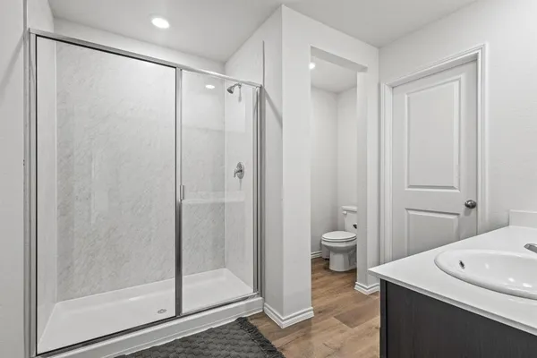 a bathroom with a granite countertop sink a toilet and shower