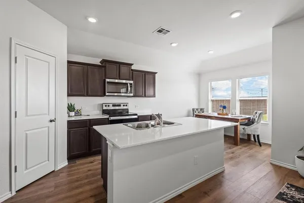 a kitchen with sink a microwave and cabinets