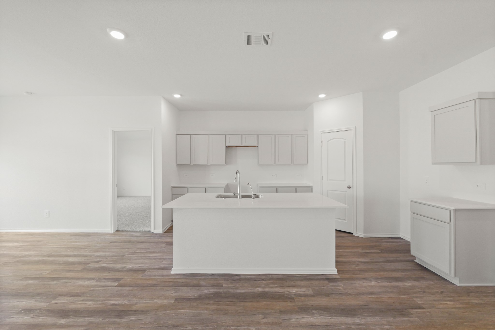 14392 Oceanblue Way Splendora, TX 77372 - Photo 7 of 30 a view of a kitchen with white cabinets and wooden floor