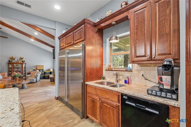 a kitchen with stainless steel appliances granite countertop a refrigerator and a sink