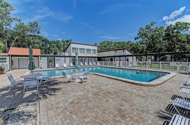 a view of a house with pool and chairs