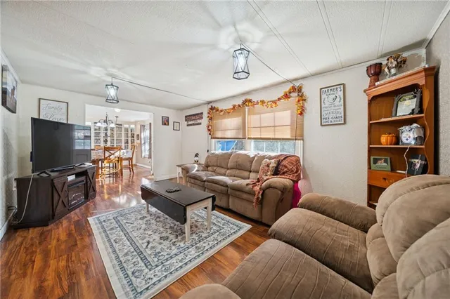 a living room with furniture a flat screen tv and a table