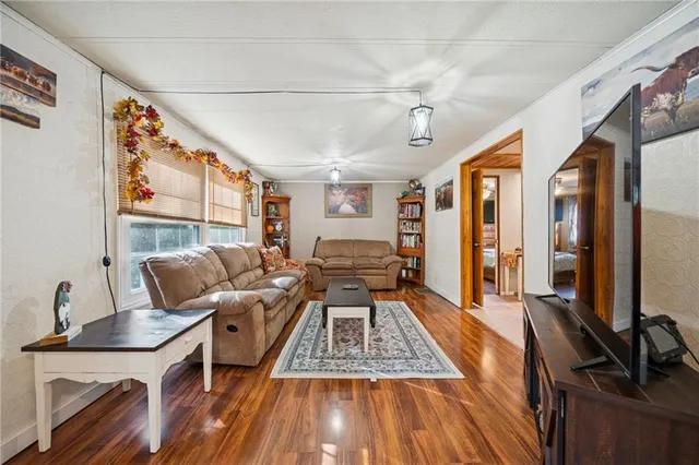 a living room with furniture stove and wooden floor