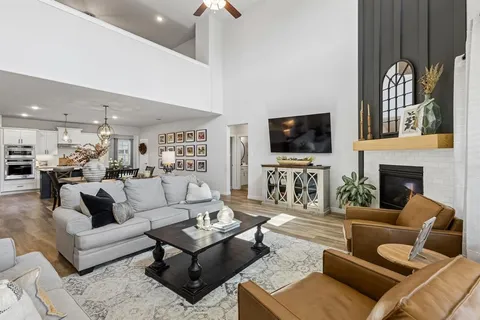 a living room with furniture a fireplace and a flat screen tv