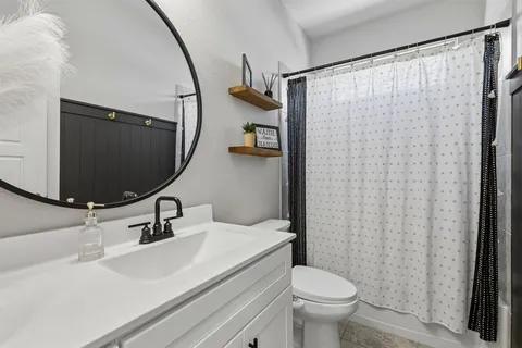 a bathroom with a sink toilet and mirror