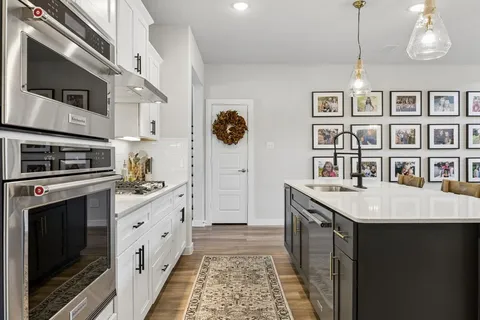 a kitchen with stainless steel appliances granite countertop a stove a sink and a refrigerator