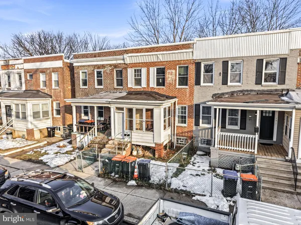 a front view of a house with cars parked