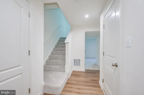 a view of a hallway with wooden floor and entryway