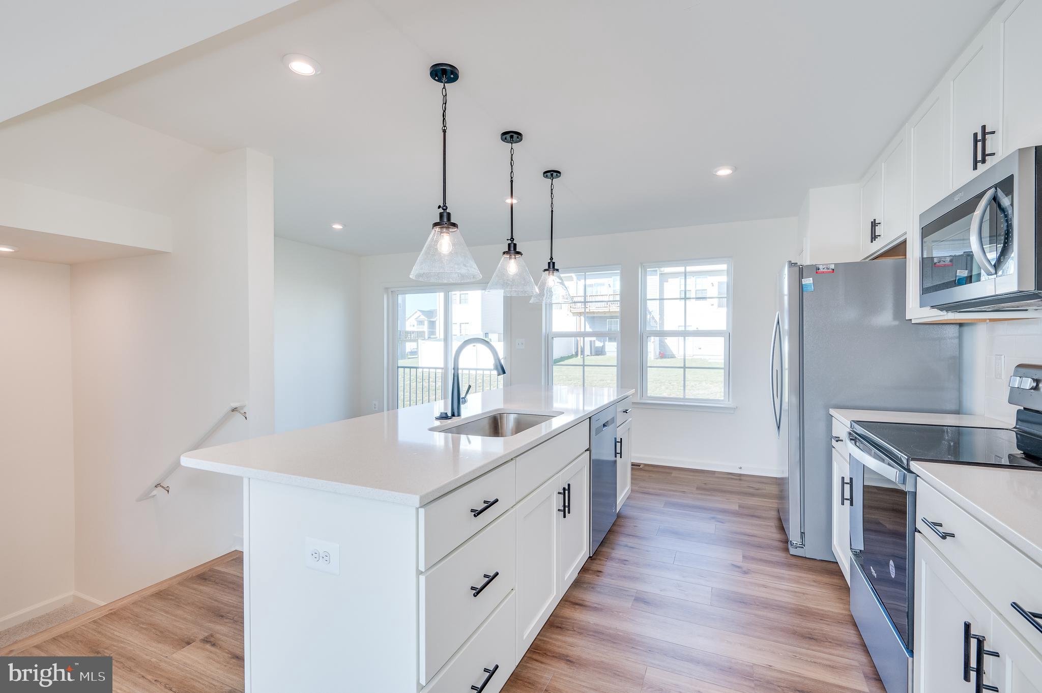 115 Tuxford Road Falling Waters, WV 25419 - Photo 17 of 44 a large kitchen with kitchen island a sink appliances wooden floor and a window