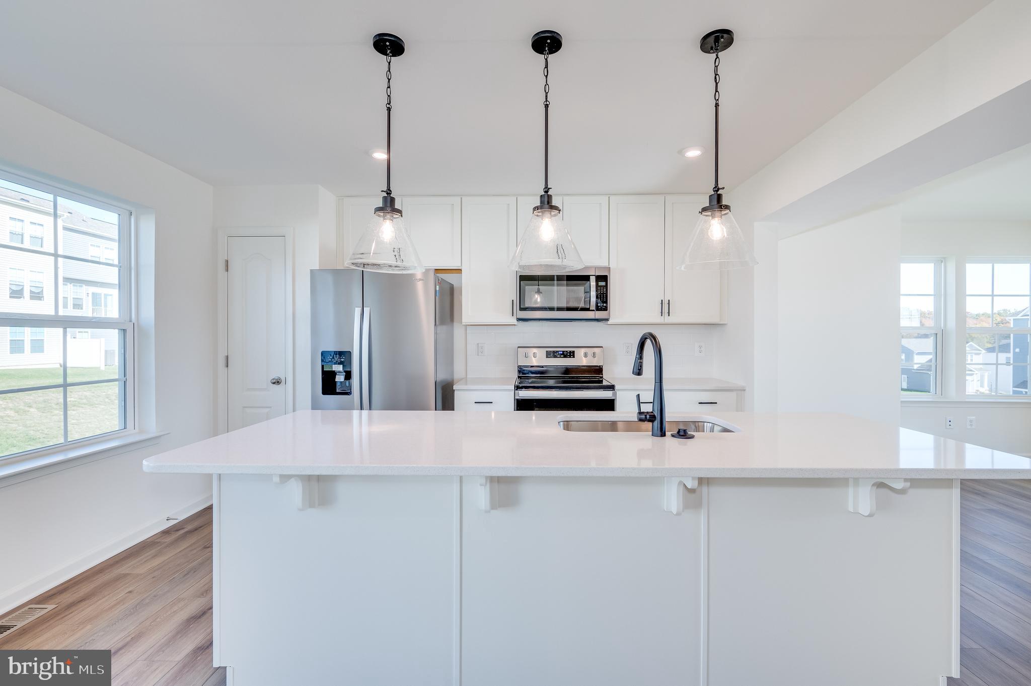 115 Tuxford Road Falling Waters, WV 25419 - Photo 19 of 44 a kitchen with stainless steel appliances kitchen island granite countertop a refrigerator a sink and white cabinets