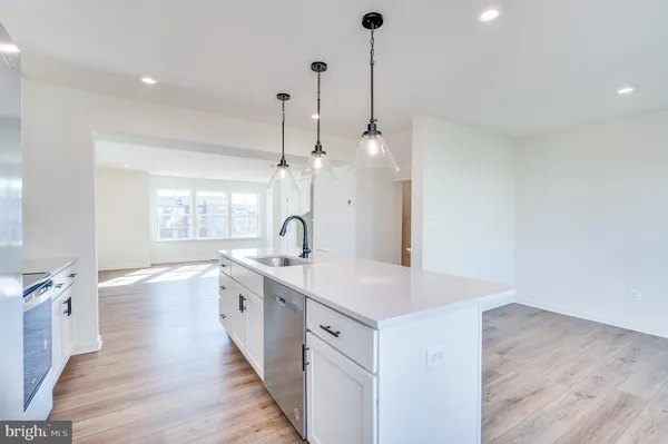 a kitchen with stainless steel appliances a stove microwave and sink