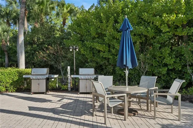 a view of a patio with a dining table and chairs with wooden fence