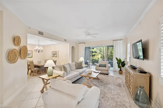 a living room with furniture a flat screen tv and a large window