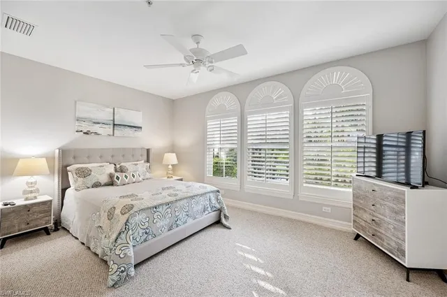 a bedroom with a bed a chandelier and a window