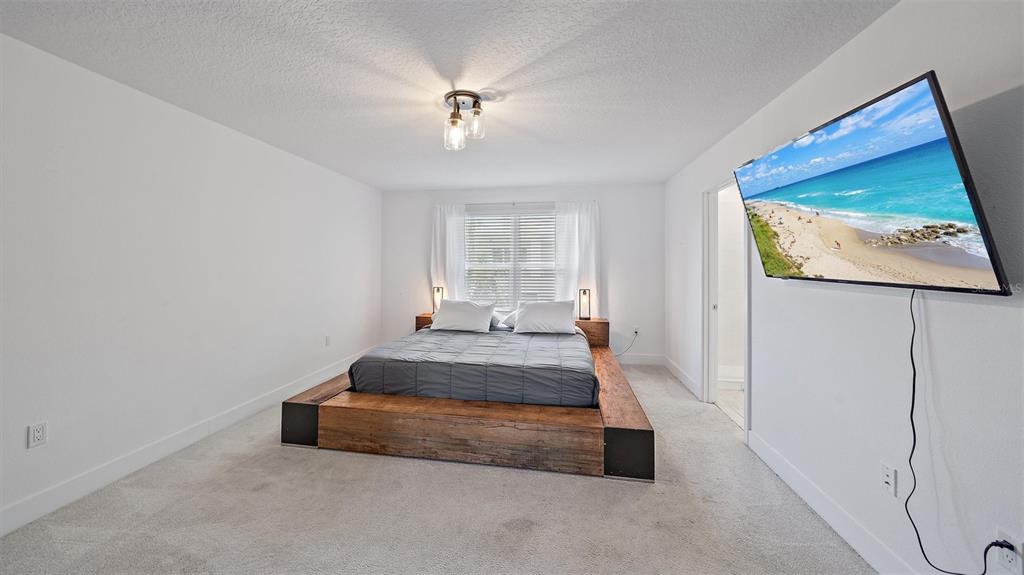 2587 Temple Street Sarasota, FL 34239 - Photo 24 of 54 a spacious bedroom with a bed and window