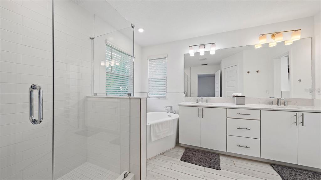 2587 Temple Street Sarasota, FL 34239 - Photo 28 of 54 a spacious bathroom with a shower a sink and a mirror