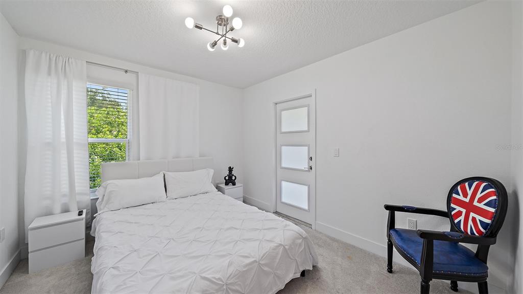 2587 Temple Street Sarasota, FL 34239 - Photo 32 of 54 a bedroom with a bed and a chair