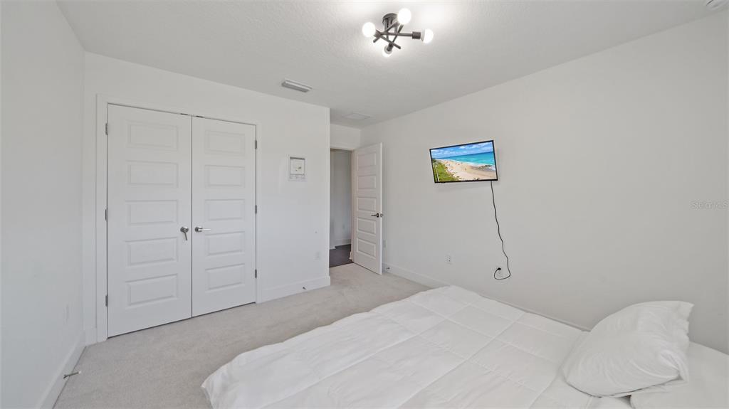 2587 Temple Street Sarasota, FL 34239 - Photo 36 of 54 a bedroom with a bed and a chandelier