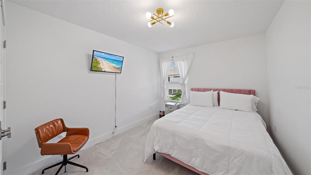 2587 Temple Street Sarasota, FL 34239 - Photo 40 of 54 a bedroom with a bed and a chandelier