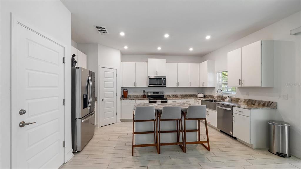 2587 Temple Street Sarasota, FL 34239 - Photo 6 of 54 a kitchen with a refrigerator a stove and a sink