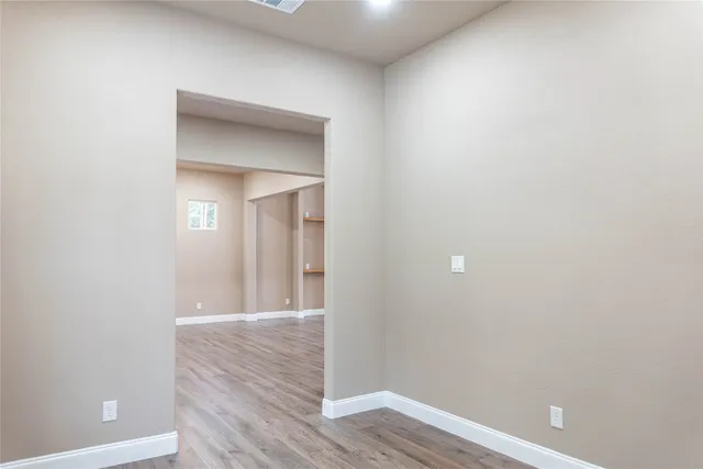 a view of living room with kitchen island wooden floor and stainless steel appliances