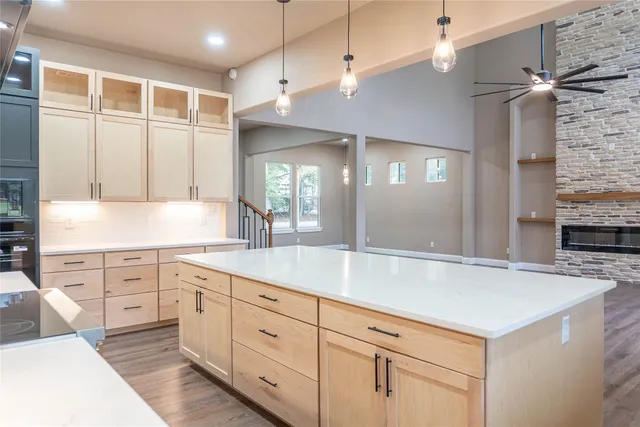 an empty room with wooden floor cabinet and windows