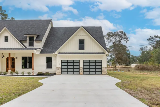 a front view of a house with a yard outdoor seating and garage