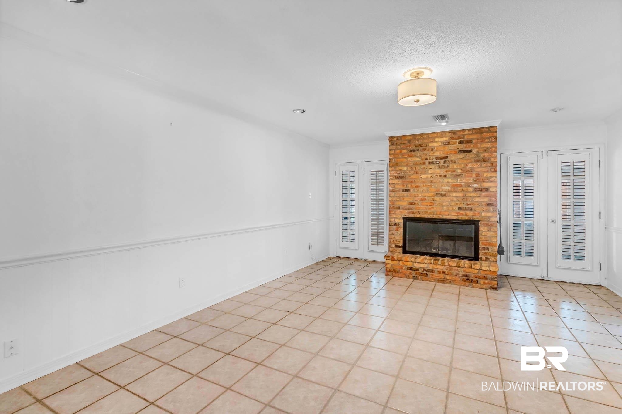 309 West Brandy Run Road Mobile, AL 36608 - Photo 10 of 100 Unfurnished living room featuring light tile patterned floors, a fireplace, and a textured ceiling