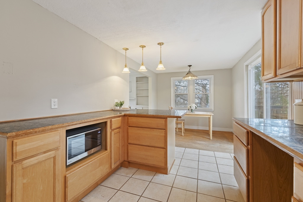 283 Orchard Street Millis, MA 02054 - Photo 11 of 41 a kitchen with granite countertop a sink stove and cabinets