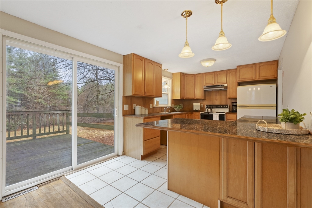 283 Orchard Street Millis, MA 02054 - Photo 12 of 41 a kitchen with stainless steel appliances granite countertop a refrigerator a sink dishwasher a stove and white cabinets with wooden floor