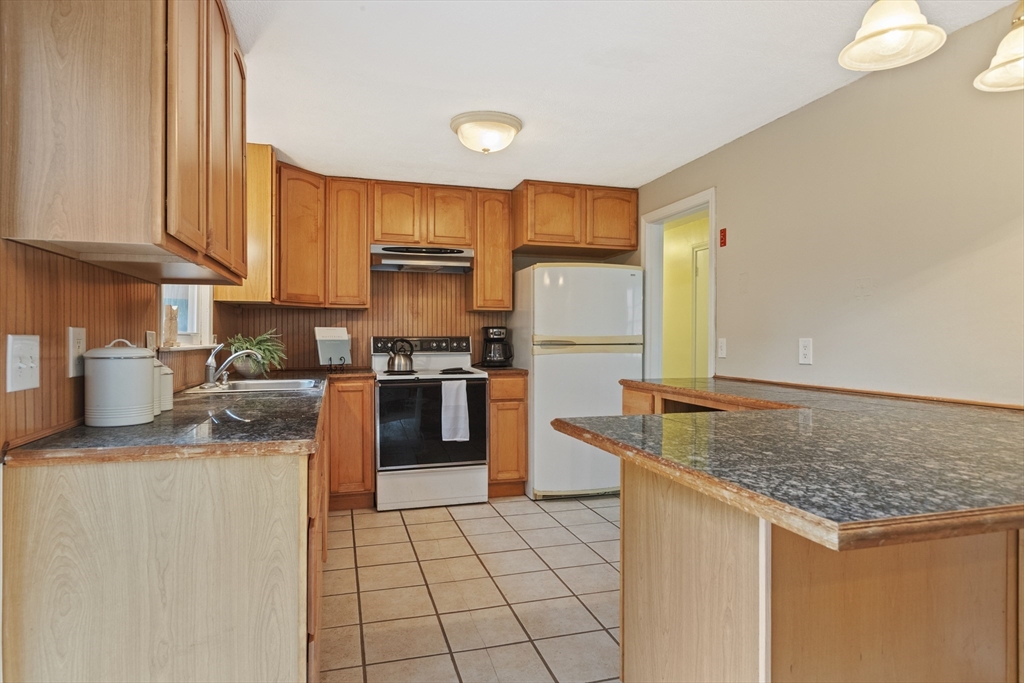 283 Orchard Street Millis, MA 02054 - Photo 13 of 41 a kitchen with stainless steel appliances granite countertop a stove a sink and a refrigerator