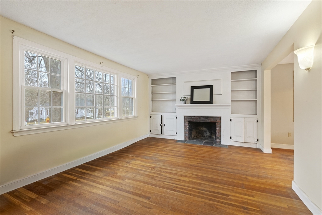 283 Orchard Street Millis, MA 02054 - Photo 4 of 41 a view of an empty room with wooden floor fireplace and a window