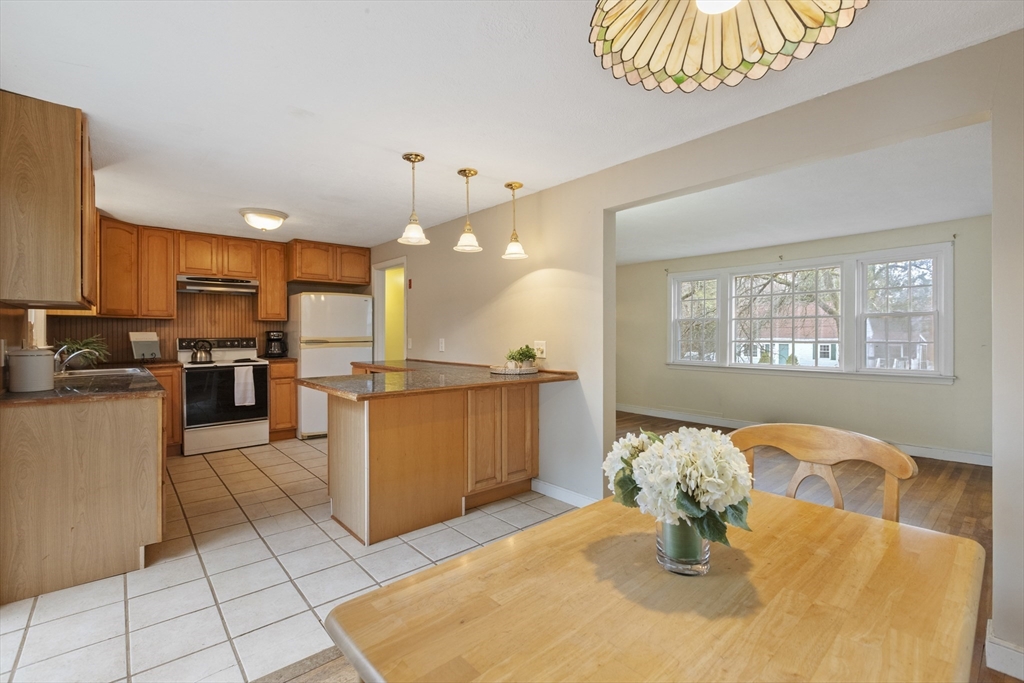 283 Orchard Street Millis, MA 02054 - Photo 9 of 41 a kitchen with stainless steel appliances kitchen island granite countertop a refrigerator a stove a sink dishwasher with a dining table and chairs