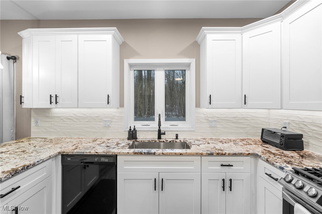 39600 Aurora Road Solon, OH 44139 - Photo 16 of 49 Kitchen with white cabinetry, black dishwasher, and decorative backsplash