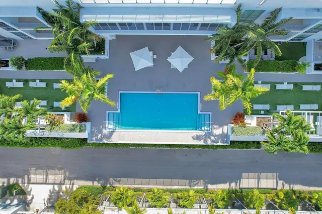a front view of a house with a yard with potted plants