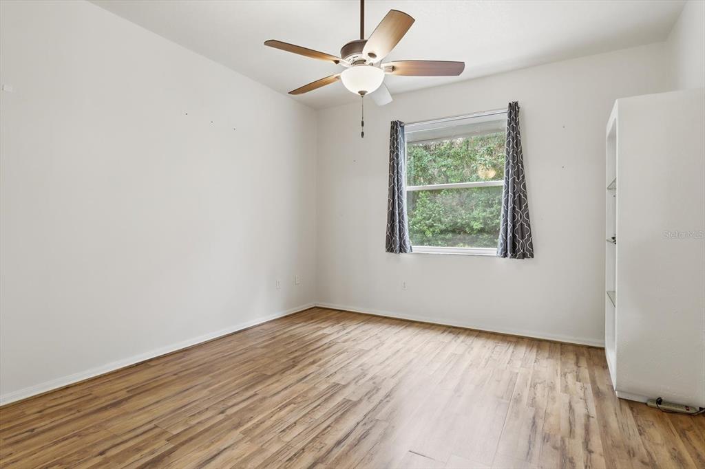 3569 South Belgrave Drive Inverness, FL 34452 - Photo 15 of 70 an empty room with wooden floor chandelier fan and windows