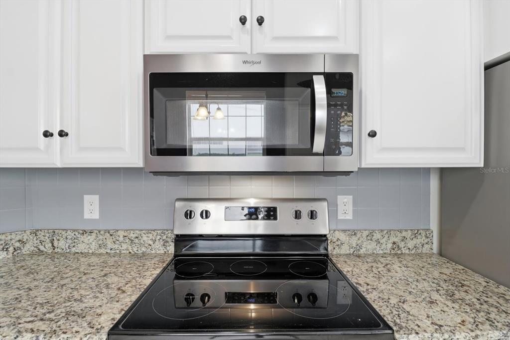 3569 South Belgrave Drive Inverness, FL 34452 - Photo 23 of 70 a kitchen with granite countertop a stove and a white cabinets