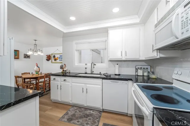 a kitchen with granite countertop a sink stove and cabinets