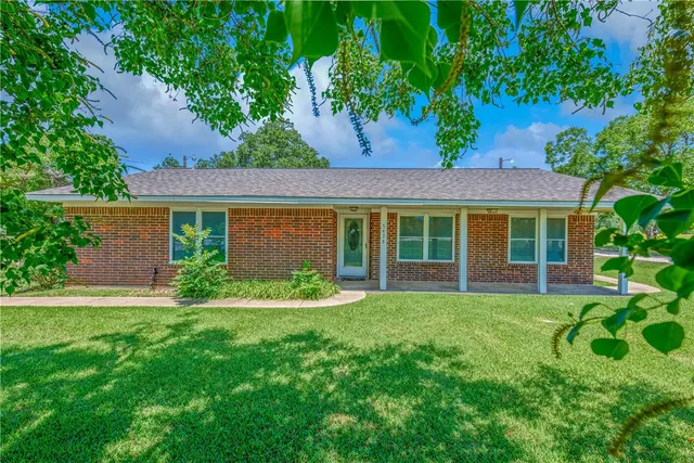 a view of a house with a yard and a garden