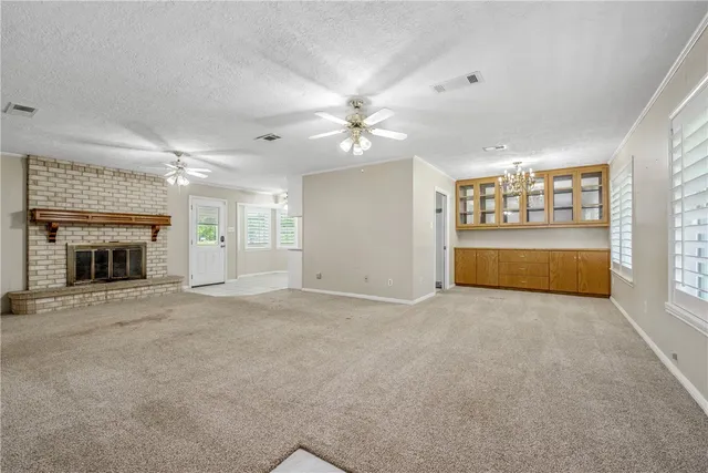 an empty room with a fireplace and window