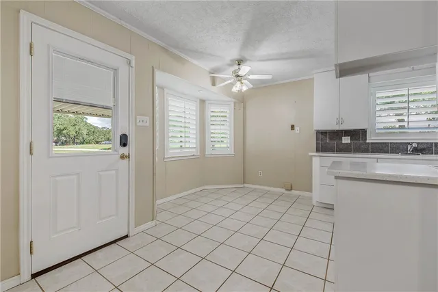 a view of kitchen with granite countertop cabinets a sink and a window