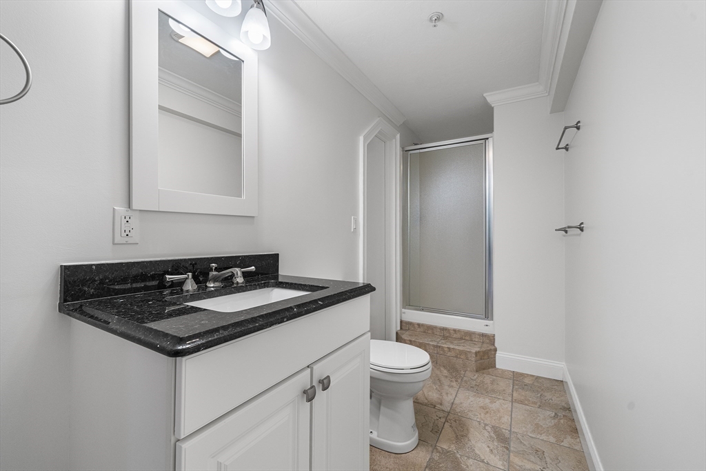 215 Rangeway Road, Unit 31 Billerica, MA 01862 - Photo 32 of 40 a bathroom with a granite countertop sink a toilet and a mirror