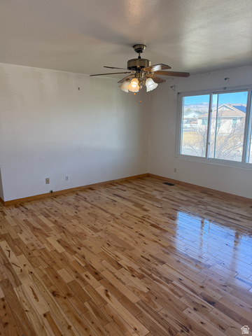 1259 West Raintree Drive Price, UT 84501 - Photo 6 of 10 Unfurnished room with light wood-style flooring, a ceiling fan, and a textured ceiling