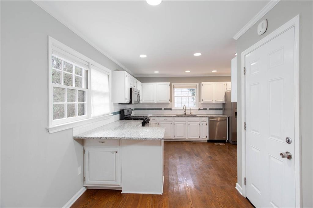 1066 Foreststone Way Marietta, GA 30064 - Photo 13 of 53 a kitchen with stainless steel appliances granite countertop a sink cabinets and wooden floor