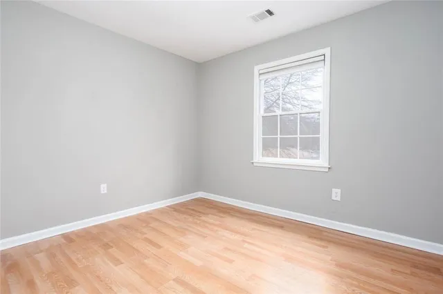 an empty room with wooden floor and closet