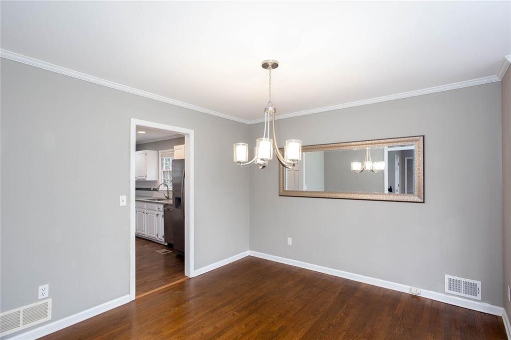 1066 Foreststone Way Marietta, GA 30064 - Photo 6 of 53 an empty room with wooden floor chandelier and windows